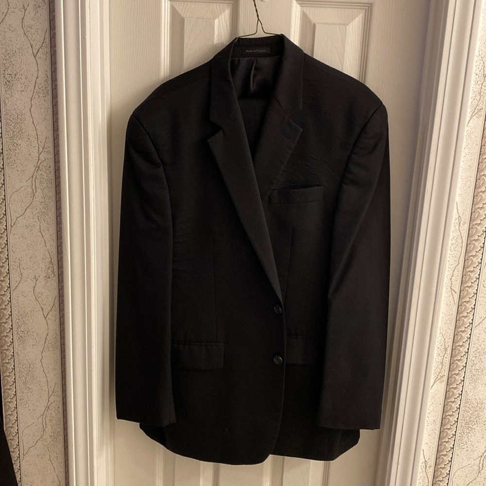 Chaps men’s black suit jacket is 2 button, pants are cuffed/pleated.